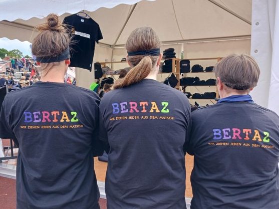 Die selben drei BERTAZ Team Mitglieder in Rückansicht mit dem Tagesmotto der BERTAZ - Wir ziehen jeden aus dem Matsch